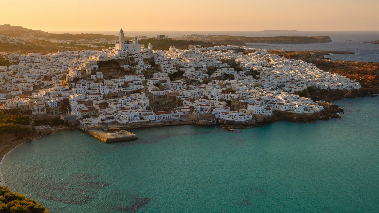 Whitewashed Andalusian coastal town at golden hour — the Spain move this cost guide budgets for